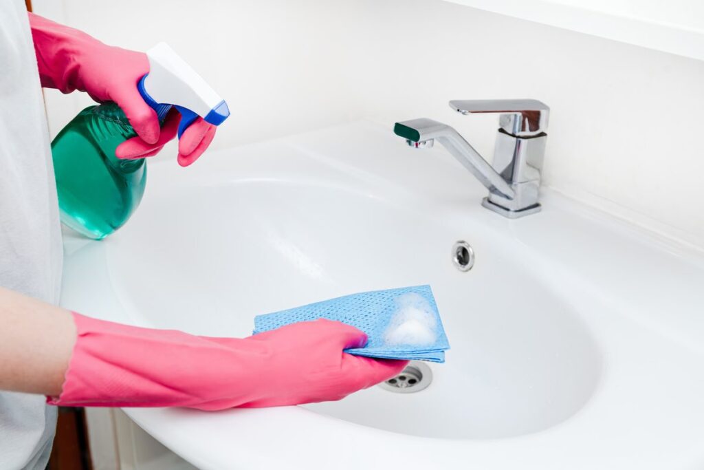 Cleaner scrubbing a bathroom sink during a deep cleaning in Centerville